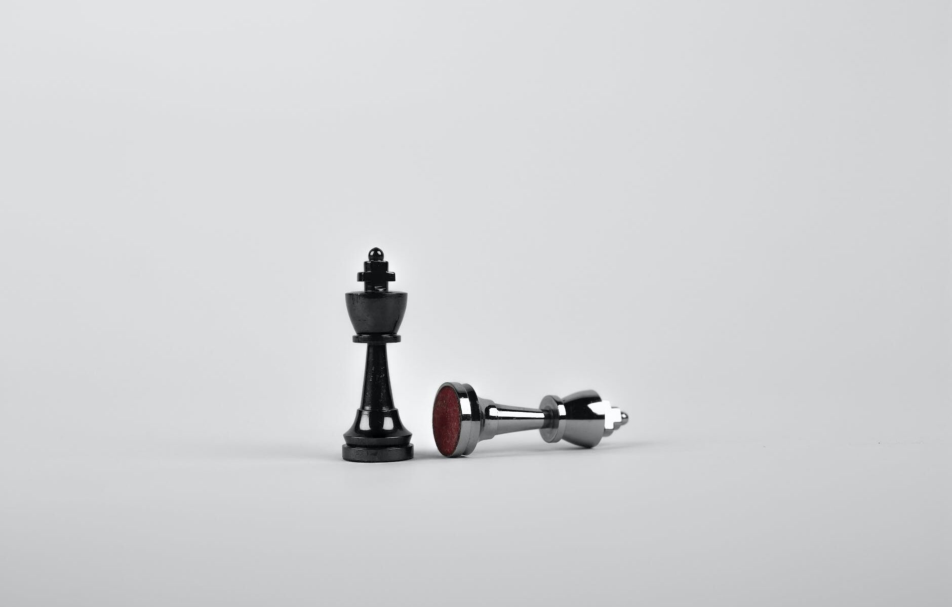 two silver chess pieces on white surface