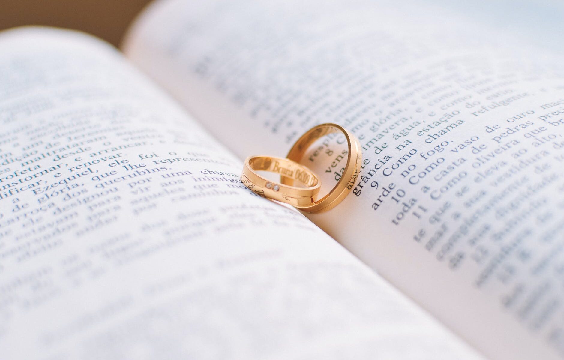 two gold colored wedding bands on book page