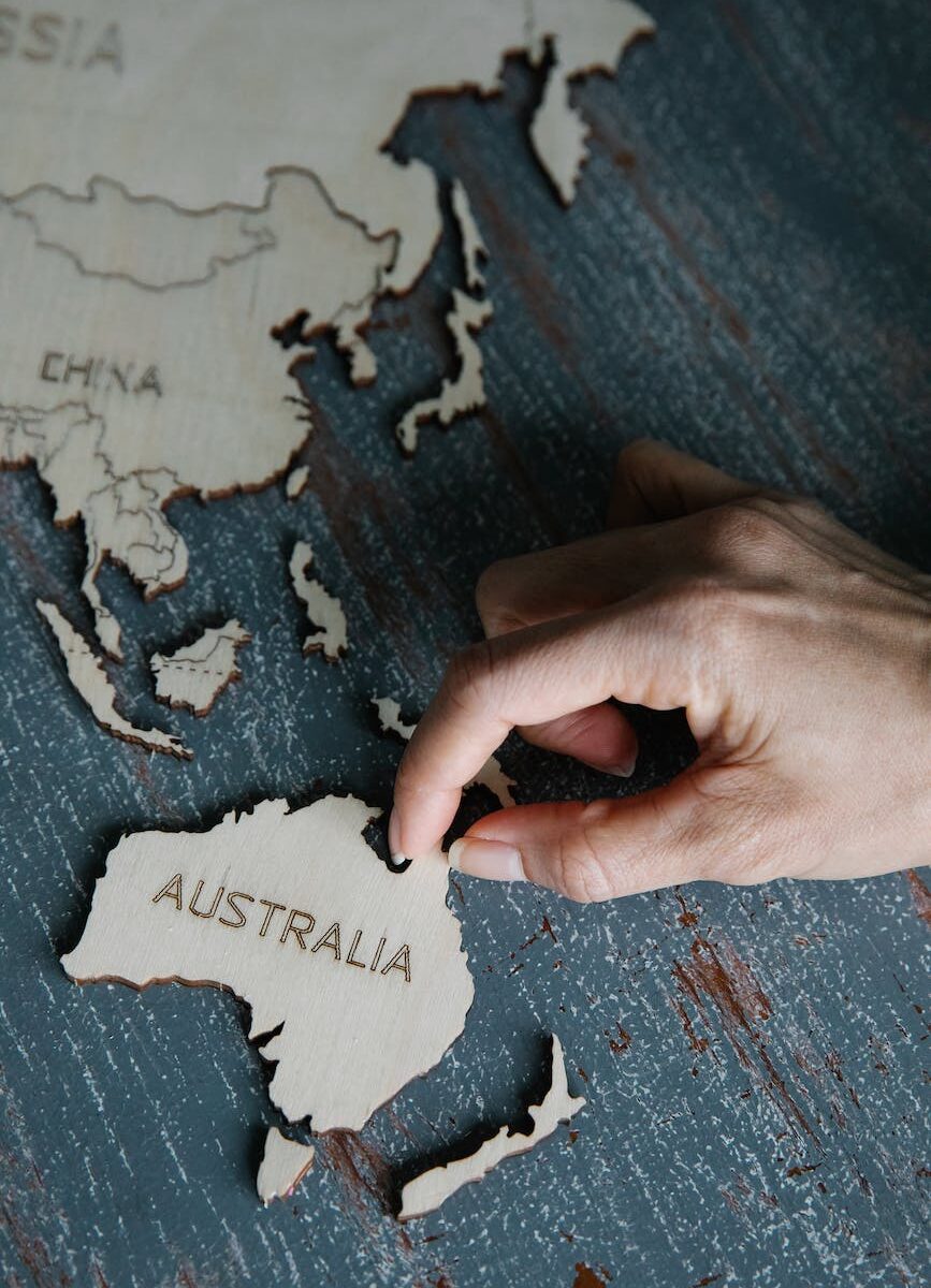 person holding wooden puzzles in shape of continents and countries