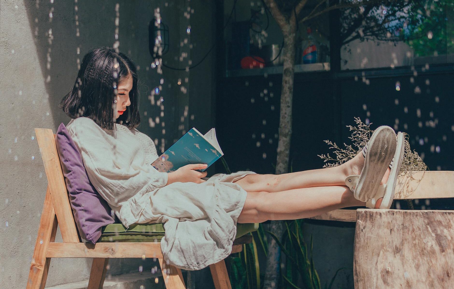 woman sitting on chair while reading book