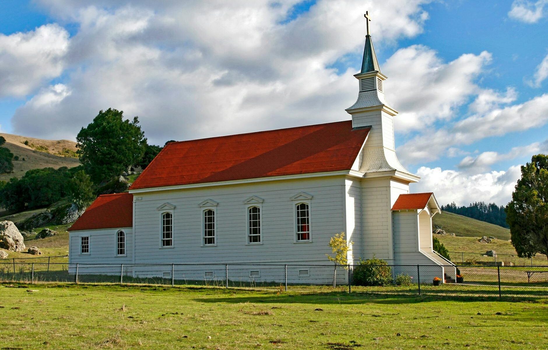 red and white concrete church on green grass field