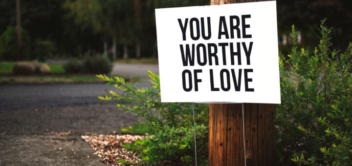 you are worthy of love signage on brown wooden post taken